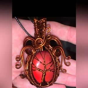 Coral colored pendant wire wrapped tree of life.